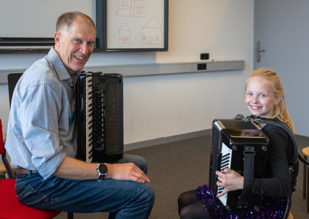 Een kind en een man met een accordeon